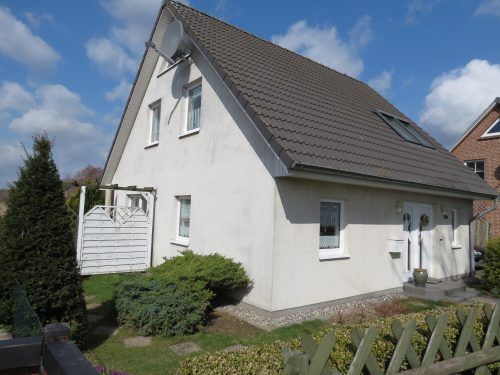 Ein kleines Haus mit einem weißen Dach und einem Zaun umgibt die gemütliche Wohnatmosphäre.