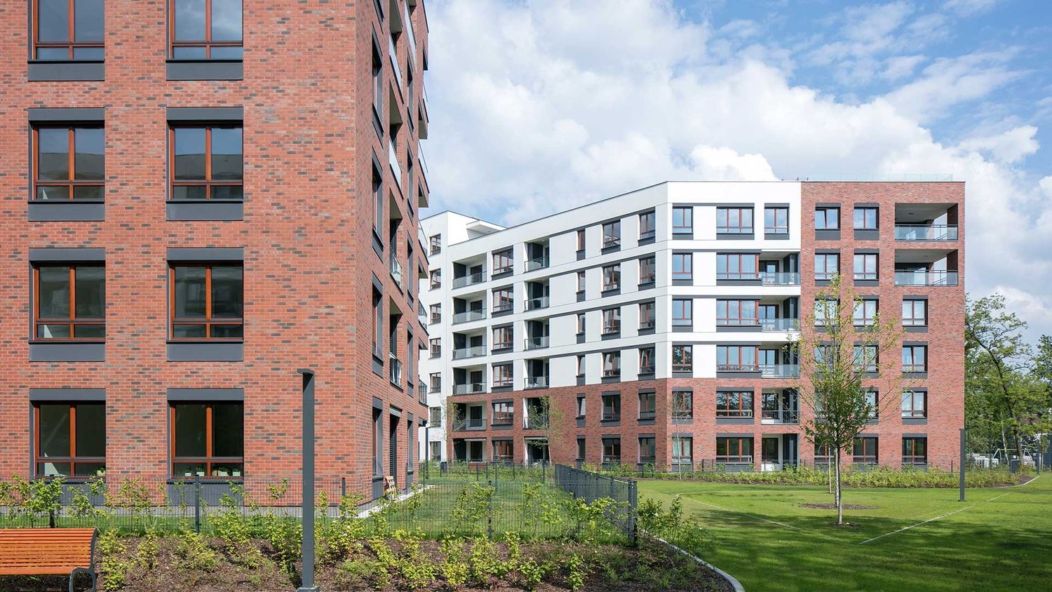 Un grand bâtiment avec un banc devant, offrant un espace de repos agréable pour les passants.