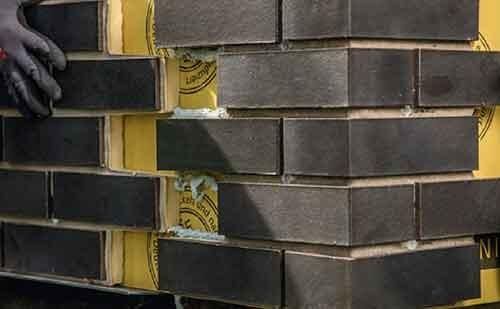 Un homme fixe la pièce de façade appropriée au mur.