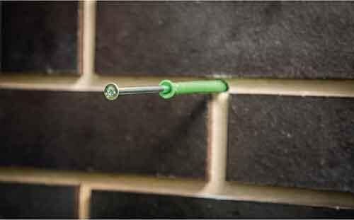 A man is drilling for fastenings; setting suitable plugs and screws.