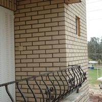 Ein Gebäude mit blick auf einen Balkon mit Metallgeländer.