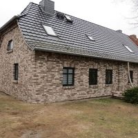 Ein Haus mit einem Ziegeldach und Fenstern, das eine einladende und traditionelle Architektur ausstrahlt.
