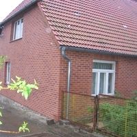 Une charmante maison en briques rouges avec un extérieur bien entretenu et une entrée accueillante.