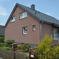 Ein großes Backsteingebäude mit einen gepflegten Garten.