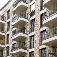 Ein Gebäude mit mehreren Balkonen, die außen an der Fassade angebracht sind, bietet einen modernen architektonischen Stil.