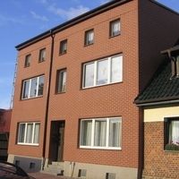 Großes Backsteingebäude mit solider Struktur und traditionellem Design, umgeben von einer gepflegten Umgebung.