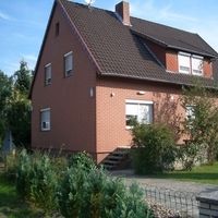 Ein großes braunes Haus mit einem einladenden Erscheinungsbild und einem gepflegten Garten.