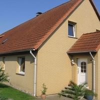Ein Haus in einen Sandton mit orangenen Dach.