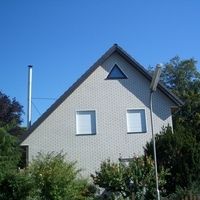 Ein Haus mit einer Uhr an der Vorderseite, das eine charmante und einladende Atmosphäre ausstrahlt.