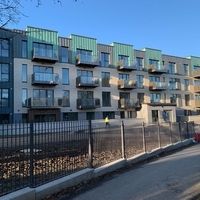 Un grand immeuble résidentiel avec de nombreux balcons qui respire une architecture moderne et une atmosphère de vie animée.