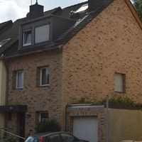 Ziegelgebäude mit klaren Linien und traditioneller Architektur, umgeben von einer grünen Landschaft.