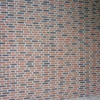 Mur de briques avec un motif de briques caractéristique qui présente une surface robuste et texturée.