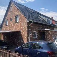Ein Haus mit einem Auto, das davor geparkt ist, in einer ruhigen Wohngegend.