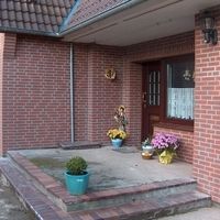 Liebevoller Eingangsbereich eines Backsteingebäudes.