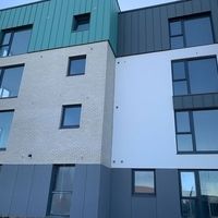 Ein Gebäude mit einer grünen und weißen Fassade, das modern und einladend wirkt.