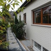 Ein Haus mit einem Gehweg und einem Fenster, umgeben von einer einladenden Umgebung.