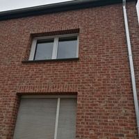 Brick building with one window and one door, representing classical architecture.