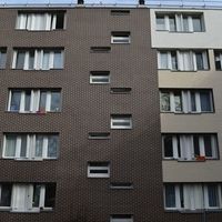 Ein Gebäude mit zahlreichen Fenstern und einer Uhr an der Seite, das eine moderne Architektur verkörpert.
