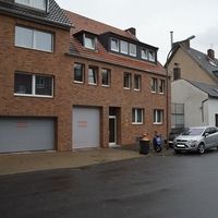 Ein Auto, das vor einem Gebäude geparkt ist, mit klarer Sicht auf die Fassade und die Umgebung.