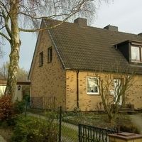 Ein großes braunes Haus mit einem einladenden Erscheinungsbild und einem gepflegten Garten.