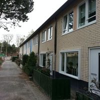 Eine Reihe von Häusern, die in einer urbanen Umgebung nebeneinander stehen, mit klaren Linien und unterschiedlichen Farben.